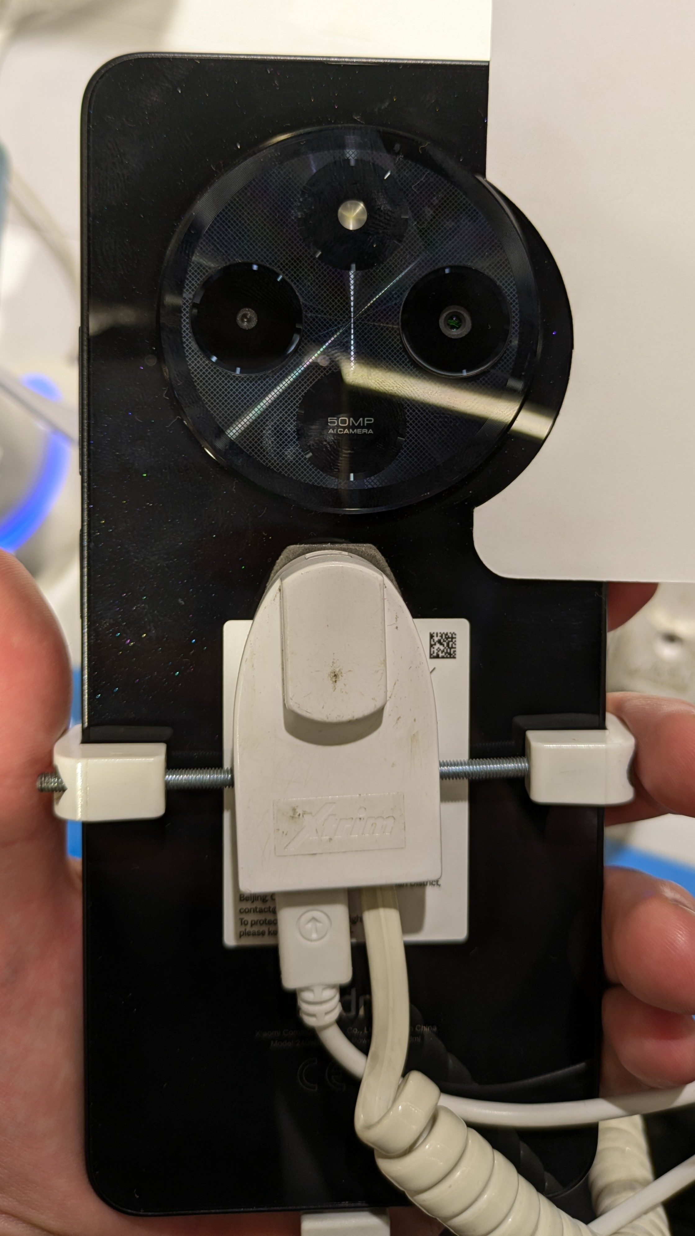 Rear camera module of a Midnight Black Redmi 14C on a shop display